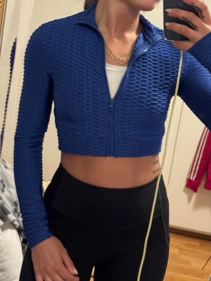 Blå cropped träningsjacka / tröja - Oanvänd blå sport topp i storlek S.