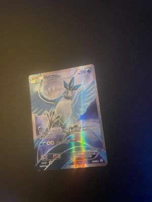 Articuno Pokémonkort holo - Säljer ett Articuno Pokémonkort med holografisk effekt. Kortet har en blå och silver design med Articuno i mitten och text på engelska. Perfekt för samlare eller Pokémonfans som vill utöka sin kortsamling.