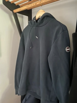 Mörkblå hoodie från Colmar - Snygg mörkblå hoodie från colmar. Säljer pågrund av att den inte längre passar. Hoodien är i bra skick. Storlek M!