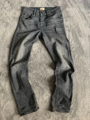 Grå slim fit jeans från Jack and Jones  - Snygga grå slim fit jeans från Jack and Jones med klassisk femficksmodell och diskret tvättade detaljer. Jeansen har raka ben och är tillverkade i mjuk denim med en modern look. Perfekta för dig som gillar stilrena och trendiga plagg. Hör av dig vid minsta fundering och pris kan diskuteras! 💯🙌