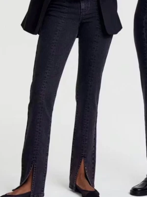 Svarta jeans med slits från Gina Tricot - Säljer ett par svarta jeans från Gina Tricot i modellen 'perfect jeans'. De har medel hög midja, smal passform och slitsar längst ner på benen. Klassisk femficksdesign och medel stretchigt material för skön känsla. En av bälteshällorna har åkt av och blivit tillbaka syd. Byxorna är ganska långa jag är 1.80 och de går över mina skor 🌸