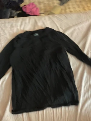 Svart långärmad tröja H&M Basic - En svart långärmad tröja från H&M Basic i ekologisk bomull. Enkel och stilren modell med rund halsringning, perfekt att matcha med olika outfits. Passar dig som gillar basic-plagg med skön passform.