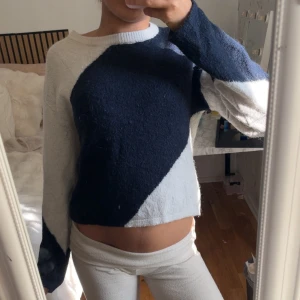 Blåvit stickad tröja Gina Tricot - Säljer en snygg stickad tröja från Gina Tricot i blått och vitt med coolt blockmönster. Tröjan har rund halsringning och långa ärmar. Perfekt för dig som gillar en avslappnad men trendig stil.