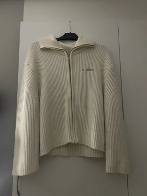 Ribbstickad kofta - En skön rätt så tjockt stickad ljus begie kofta. Tröjan är väldigt stor i passformen men väldigt skön. (Köpte den på Falsterbo horse show hos Gina Tricot där av att de står Falsterbo på den) Den är som ny då den aldrig har blivit använd.