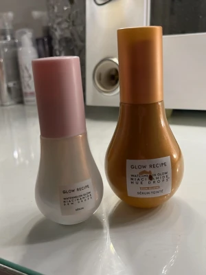 Glow Recipe Watermelon Glow dropps, dewy dropps  - Två serum från Glow Recipe i droppformad flaska. En är ljusrosa med rosa lock och en är varm brun med guldigt lock. Båda har etikett framtill och innehåller niacinamid för extra glow. Ljusrosa flaskan är mer än halva kvar och bruna är hela kvar. Ens blev repig efter att jag råkat trycka in den i mitt skrivbord så inget som skada själva innehållet 