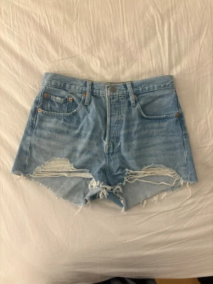 Levis 501 shorts blå - Köpta för några år sedan , använda kanske 2 ggr då den inte riktigt passar. I övrigt väldigt fina men får sälja eftersom de inte sitter så bra på just mig. Tror storleken är 25 men är osäker då det inte står i dem och jag inte kan hitta beställningen.