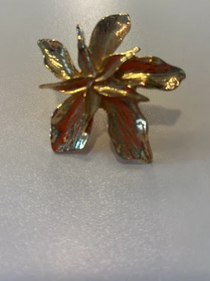 Stor guldfärgad blomring - Statementring i form av en stor blomma i guldfärgad metall.