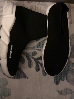 Balenciag Speed Trainer sneakers -  Speed Trainer sneakers med vit chunky sula och stickad strumpliknande ovandel. Loggan står tryckt på sidan. Skorna har en modern, slimmad siluett och är tillverkade i textil och gummi för en futuristisk look.