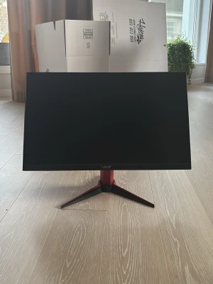 Acer datorskärm med röd fot - Säljer en stilren Acer datorskärm med svart matt finish och en snygg röd stativfot i metall. Skärmen har tunna kanter och modern design, perfekt för gaming eller arbete. Passar till de flesta datorer och har en stabil konstruktion. Den har även 165mhz