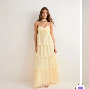 Ljusgul långklänning med volanger - Ljusgul klänning som passar perfekt till balen. Den är oanvänd med prislappen kvar från Nelly, i storlek S!!💓