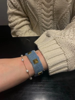 Nitarmband 💙 - Superfint blått nitarmband i jeans med guldiga detaljer. På armbanden är det en knapp och ett hål för att kunna fästa det runt handleden, omkretsen på armbandet är ca 18 cm från knappen till hålet! 💙
