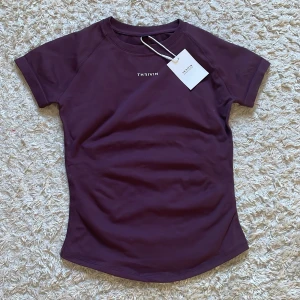 Tränings tröja från Thrivin - Snygg vinröd/mörklila tränings tröja i helt nytt skick med prislapp. Tröjan var en tight bekväm passform. Ny pris 659kr och är slutsåld på hemsidan. 