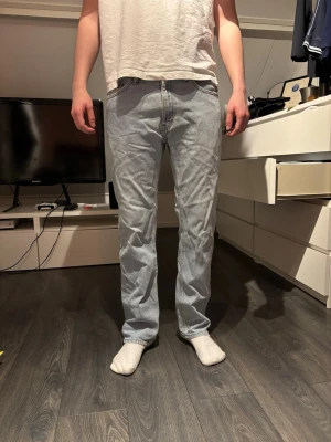 Ljusblå raka jeans Levis  - Säljer ett par ljusblå jeans med rak passform och klassisk femficksdesign. Jeansen har normal midja och är tillverkade i denim. Perfekta för en avslappnad och stilren look.