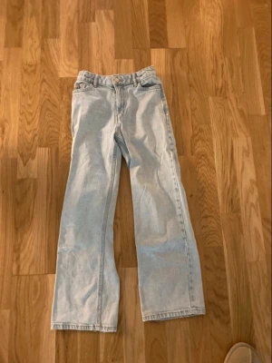 Ljusblå snygga jeans - Säljer ett par vida ljusblå jeans i strl 134. Lite nött på höger knä (se bild).