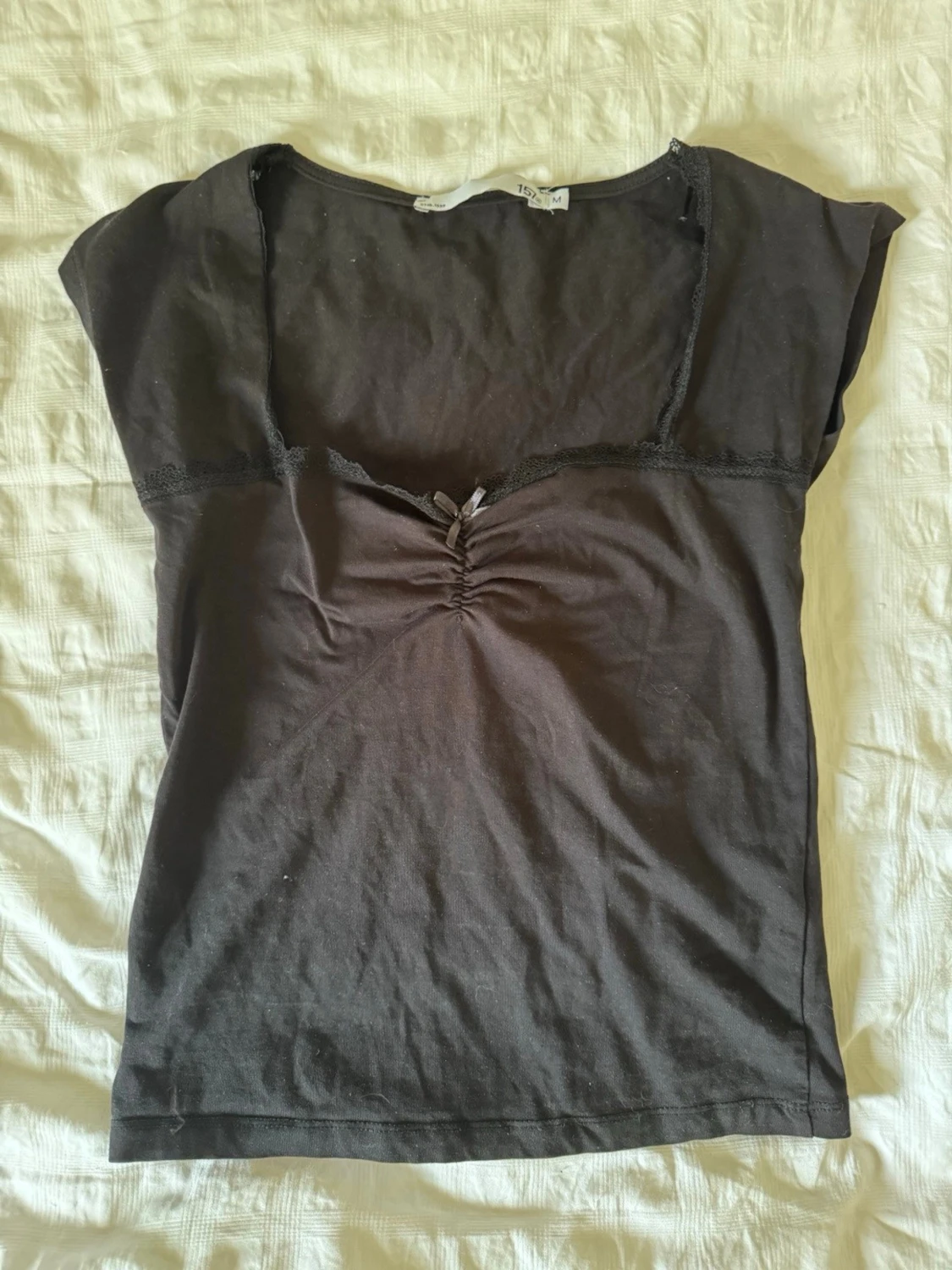 Svart topp med spets och rosett