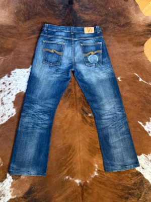 Nudie RegularRalf Bootcut - Tjena! Säljer dessa riktigt feta och sällsynta nudie regularalf/alf, byxorna har sjukt fin wash och är i storlek W33/L32 men kolla gärna måtten, modellen på bilden är cirka 188cm/ 87kg och byxorna är lite korta, hör av dig vid funderingar!🙌