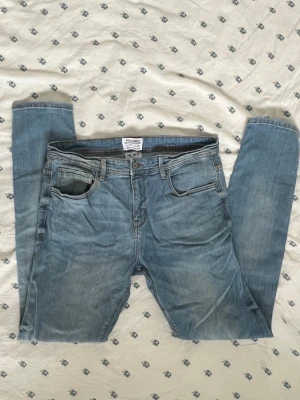 Ljusblå slim fit jeans från Pull & Bear - Säljer ett par ljusblå slim fit jeans från Pull & Bear. Klassisk femficksmodell med dragkedja och knapp i midjan. Jeansen har en snygg tvättad look och raka ben. Perfekta till en avslappnad stil. Storlek 44 alltså XXL / extra extra large. Ungefärliga mått (platta): Längs midjan: 41 cm Innerbenslängd: 75 cm Ytterbenslängd: 105 cm