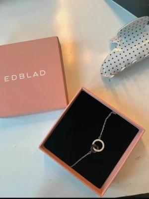 Silverarmband från Edblad  - Snyggt och stilrent armband från Edblad i silverfärg. Armbandet har en tunn kedja och två sammanlänkade cirklar. Aldrig använt. Perfekt accessoar för att lyfta din outfit. Skriv vid frågor och pris kan diskuteras! Finns ute på Vinted också, samma användarnamn. 💞💞