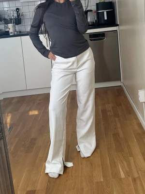 Gina Tricot vita kostymbyxor raka - Säljer ett par Vita kostymbyxor från Gina Tricot. Snygg passform och passar till allt. Bra skick. 