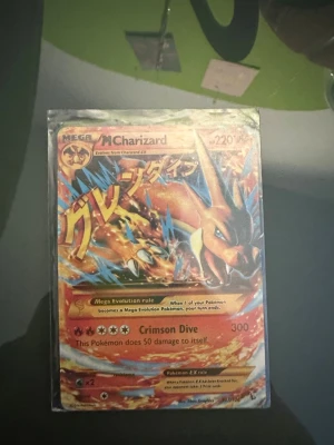 Pokémonkort Mega Charizard EX - Hej jag säljer ett Charizard kort som är i bra skick förutom små skador på baksidan men har övrigt ett bra skick. 