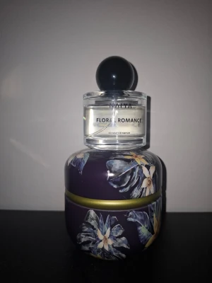 Flora Romance parfym från NAYIA - Flora Romance från Naiya är en elegant parfym i en rund glasflaska med svart klotformad kork. Perfekt för dig som gillar blommiga och romantiska dofter.