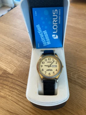Vintage Seiko Lorus Lumibrite 38mm Herrur - Säljer en riktigt snygg vintage (80/90-tals) herrklocka från japanska Lorus (Seiko) i nära nyskick enligt bilder. Guldpläteringen lite avskavd och smuts på baksidan, annars är den jättefin. Japanskt urverk som fungerar bra, armband i läder (ej original), dag och datumvisare, vattentät, osv. Behöver bara nytt batteri. Fås i snygg originalförpackning med papper. Modell: VX33-X034.  Begagnat värde: < 800 SEK Mitt pris: 489 SEK  Skickas alltid snabbt och spårbart. Skriv vid frågor och se gärna mina 
