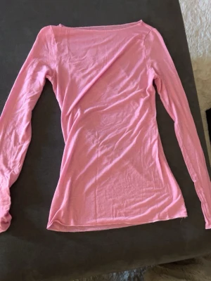 Ljusrosa intimissimi  - En enkel och stilren ljusrosa långärmad topp från intimissimi i storlek S med rund hals. Tillverkad i ett mjukt och tunt material som känns skönt mot huden. Perfekt att matcha med jeans eller kjol för en avslappnad look.
