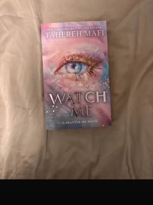 Watch Me av Tahereh Mafi - Säljer boken 'Watch Me' av Tahereh Mafi, en del av Shatter Me-serien. Omslaget har ett konstnärligt motiv med ett öga och tårar i pastellfärger som rosa, blått och lila. Perfekt för dig som gillar ungdomsdystopier och fantasy. På engelska