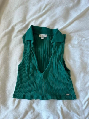 Grön ribbad linnetopp  - Snygg grön ribbad linnetopp från pull & bear med djup v-ringning och krage. Toppen är ärmlös och croppad,