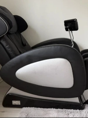 Svart massagefåtölj med touchpanel - Elektrisk massagefåtölj i svart konstläder med vita detaljer och inbyggd touchpanel. Fåtöljen har ergonomisk design, justerbart benstöd och flera massagefunktioner. Perfekt för avkoppling hemma och styrs enkelt via den monterade kontrollen.