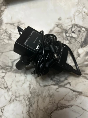 FSP Group AC/DC Adapter 50W - Svart AC/DC-adapter från FSP Group, modell FSP050-DBC01. Adapter med 12V utgång och max 4,16A (50W). Tillverkad i plast med rektangulär form och fast kabel. 