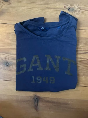 Gant tröja - Fin GANT t shirt, mörkblå med guldig text. Storlek S. Inte mycket använd. Skriv om du har frågor!