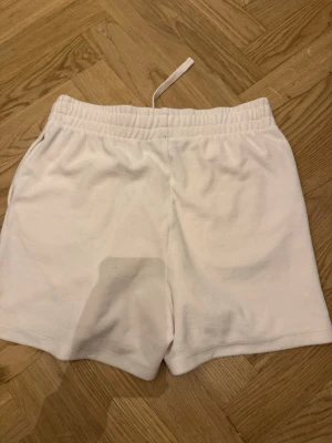 Vita mjuka shorts med resårmidja - Vita shorts från Visual Sports med elastisk midja och enkel design. Tillverkade i mjukt material som känns skönt mot huden. Perfekta för avslappnade dagar eller träning. Klassisk passform och neutralt utseende.