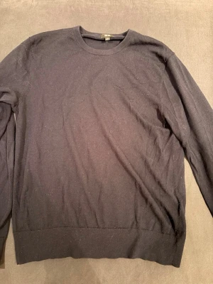 Mörkblå tröja från Uniqlo - En enkel och stilren mörkblå tröja från Uniqlo. Merinoull. Bra skick men änvänd.
