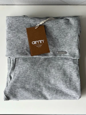 Grå yoga pants från Aim'n - Supersnygga grå ribbade leggings från Aim'n med hög midja och utsvängda ben. Tillverkade i mjukt och stretchigt material som sitter skönt på kroppen. Perfekta för en chill och trendig look. Metallogo på linningen för extra detalj. Helt nya/aldrig använda, nypris 499kr. Diskuterar gärna pris!✨