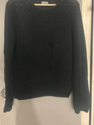 Svart grovstickad tröja Weekday - Snygg svart grovstickad tröja från Weekday med rund halsringning och långa ärmar. Tröjan har en chunky känsla och är perfekt för kyligare dagar. Enkel och stilren design som passar till det mesta.