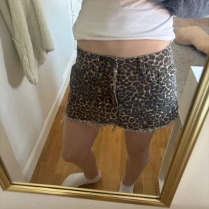 Leopardmönstrad kortkjol med rå kant - storlek s men passar även xs. Säljer en kort kjol med leopardmönster och rå, fransig kant. Kjolen har dragkedja framtill och klassisk femficksdesign. Perfekt för dig som vill sticka ut med ett djuriskt print.