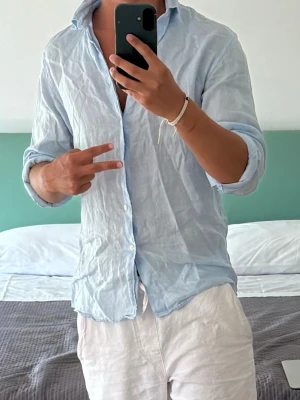 Ljusblå linneskjorta - Snygg ljusblå linneskjorta från Matinique. Perfekt till sommaren. Nypris 1699kr. Använd tre gånger så ser helt ny ut. Storlek M