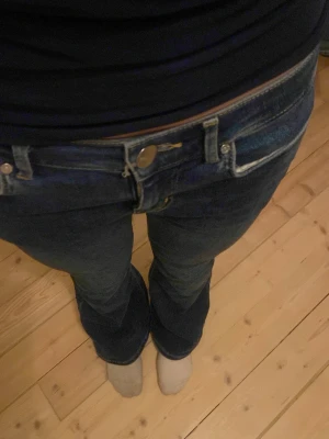 Mörkblå low flare jeans XS/31 - Säljer ett par mörkblå low flare jeans med låg midja och utsvängda ben. Klassisk femficksmodell och snygg passform. Perfekta för dig som gillar en trendig och avslappnad stil. Materialet är mjukt denim i bomull med Midja XS och Längd 31.