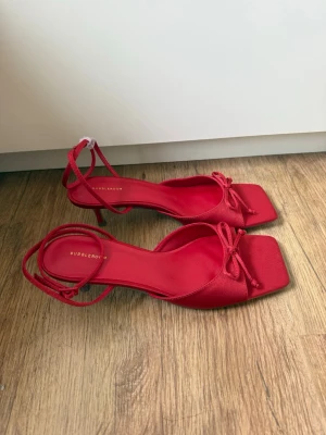 Röda klackskor  - Oanvända röda klackskor från Bubbleroom i strl 40. Låg klack, öppen tå, rosett framtill och justerbar ankelrem👠 