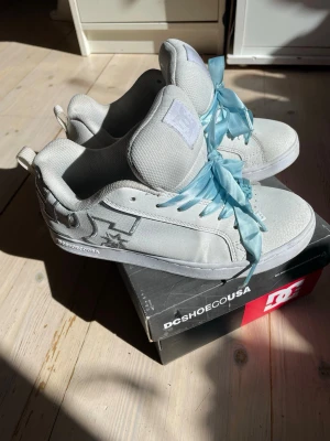 Dc skor med blå snören - Säljer mina supersnygga Dc skor! Jag älskar dem men de är tyvärr precis för små. Har därför användt dem några gånger men endast en kort stund, står även att de är o storlek 38 men jag skulle säga 37,5. Sköna, snygga skor som jag önskar kommer komma  till användning :) (läs på bild 3 om material mm, defekt bild 6)