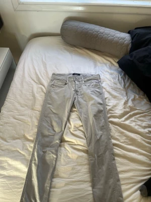 Ljusgrå jeans från Replay - Snygga ljusgrå jeans från Replay med klassisk femficksdesign och raka ben. Jeansen har en stilren look och är tillverkade i ett mjukt denimtyg som sitter skönt. Perfekta för dig som gillar en clean och modern stil.