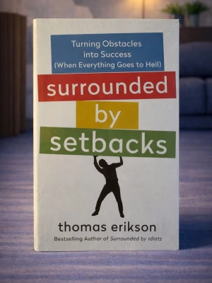 Surrounded by Setbacks (Brand new, in English) - Skick: Helt ny bok. Omslag: Pappercover. Storlek: standard (inte pocket). Förpackning: I sitt originala plastomslag. Från: Stockholm. Snabb leverans inom Sverige.