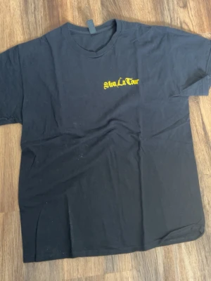 Soppgirobygget merch - Svart t-shirt med gult Viva La Tour-tryck på bröstet och stort turnétryck på ryggen. Från soppgirobygget Klassisk rund hals och korta ärmar. Perfekt för dig som gillar bandmerch och vill sticka ut med en unik tourtröja.