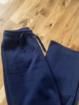 Mörkblå mjukisbyxor - Mörkblå mjukisbyxor med raka ben och resår i midjan samt skön passform. Tillverkade i mjukt och bekvämt material, perfekta för chill dagar. Klassisk modell utan synliga loggor eller detaljer.