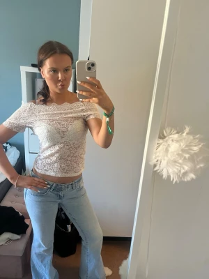 Vit spetsig offshoulder topp - Säljer en vit, offshoulder topp i spets med korta ärmar. 