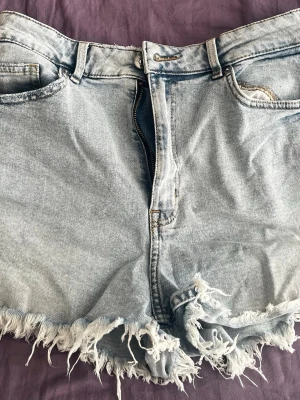 Ljusblå jeansshorts  - Säljer ett par ljusblå jeansshorts från H&M  i storlek 38. Har knappast använts
