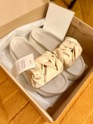 Nya Inuikii Fjord Flower Platform Sandaler - Strl.39 - Helt nya i originalkartong enligt bilder!  Strl.39  Bred rem i silkesliknande textil Mockaklädd fotbädd Sulhöjd: 4 cm Klackhöjd ca 5cm Innermått 25cm  Nypris 2899kr  Se gärna mina övriga annonser för bundlerabatter och samfrakt!