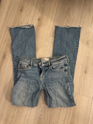 Zara jeans - Ljusblå jeans från zara med raka ben och trendiga råa benslut. Klassisk femficksmodell och bälteshällor. Perfekta för en avslappnad och cool stil. Säljer då jag inte får användning för dom