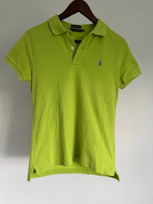 Ralph Lauren The Skinny Polo - Ralph Lauren The Skinny Polo Storlek: M/M Passform: Skinny Fit Krage: Klassisk pikékrage med tvåknapps stolpe Material: 98 % bomull, 2 % elastan Mått: Bröstvidd 88 cm, längd 60 cm, axel 38 cm Skick: Denna piké är i ett väldigt fint skick utan defekter  Nypris cirka: 1 000 kr